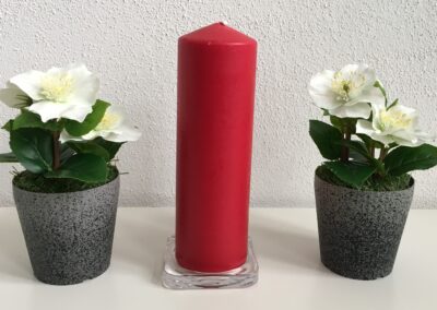 Deko: zwei Blumen und eine rote Kerze